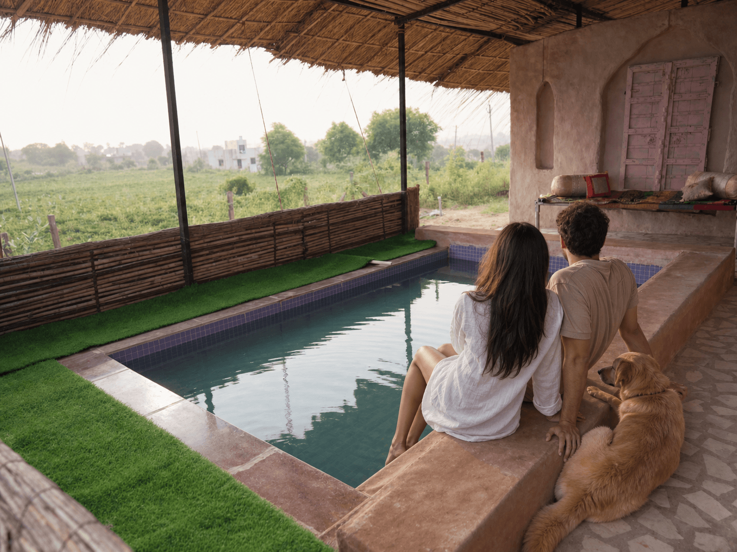 A couple and their dog relaxing beside the pool at Maru Retreat Farmstay